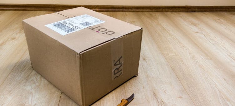 Paket auf Dielenboden mit Messer zum Öffnen Kurier Hamburg-Nord